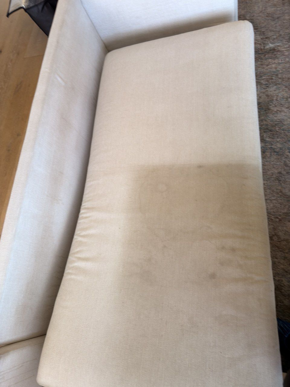 Sofa cushion half cleaned, showing the dirty side next to the clean side