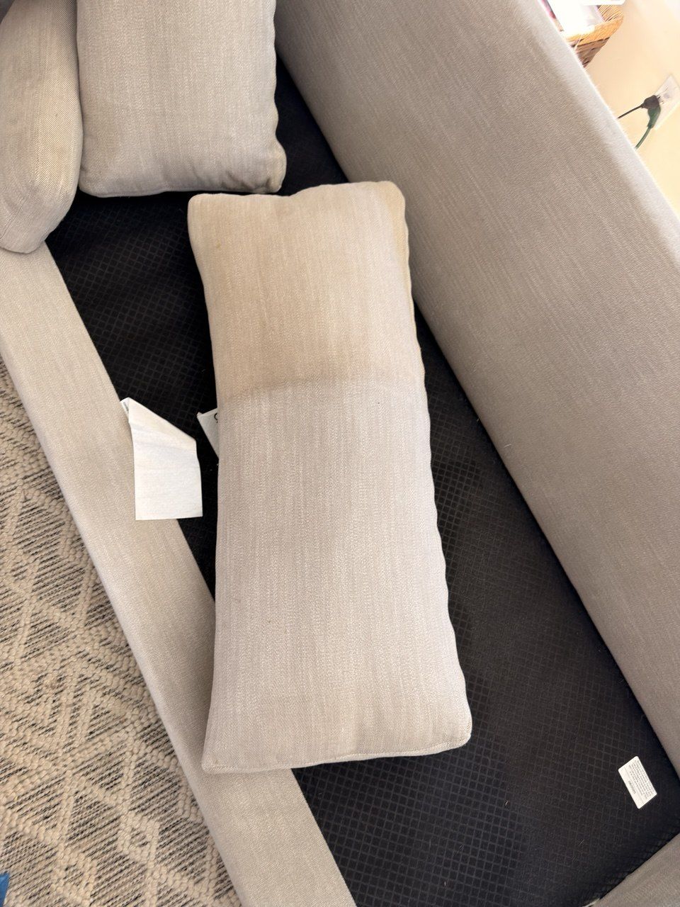 Gray lumbar cushion half cleaned to show the contrast