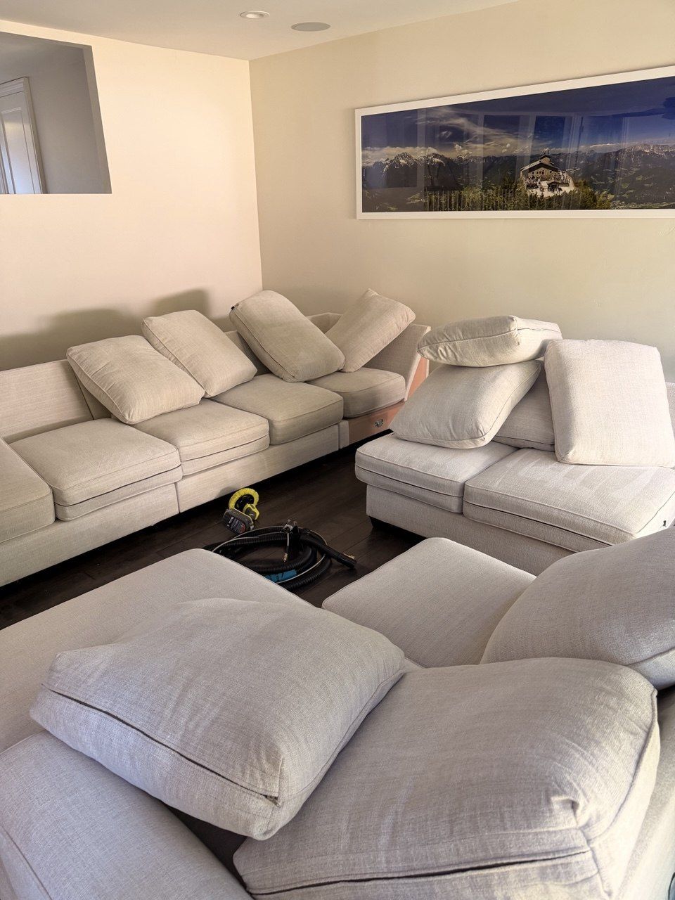 Multi-piece cream sectional set with cushions propped up to dry after cleaning