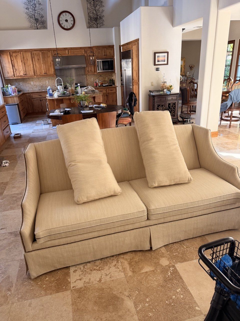 Beige skirted sofa with nailhead trim cleaned in place in a living room