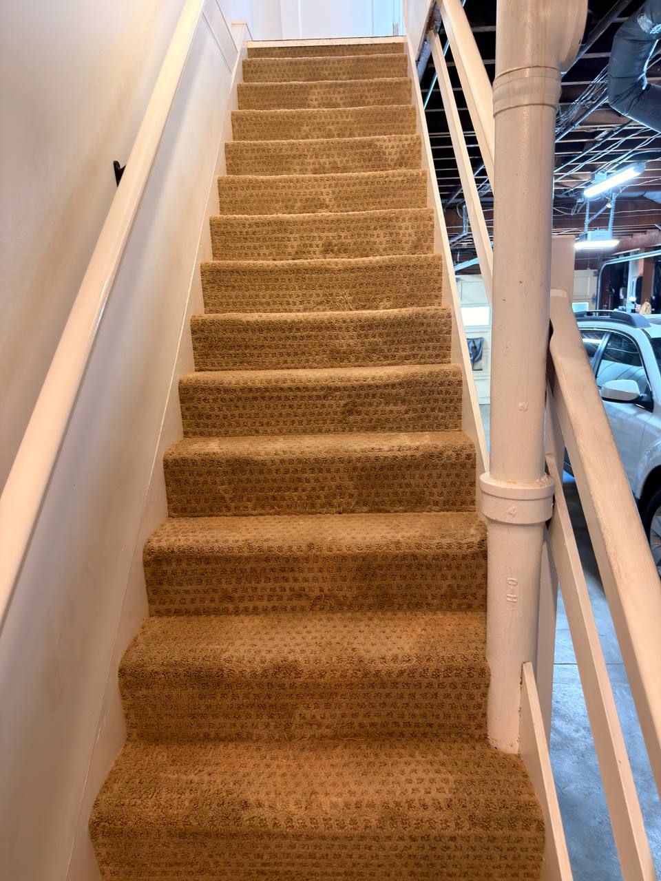 Carpeted staircase after hot-water extraction, patterned tan carpet clean and even on every step